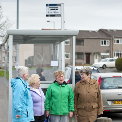 Group of older ladies waiting for a bus at the bus stop