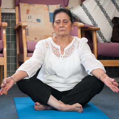 A woman sitting on the floor, with her legs crossed, meditating